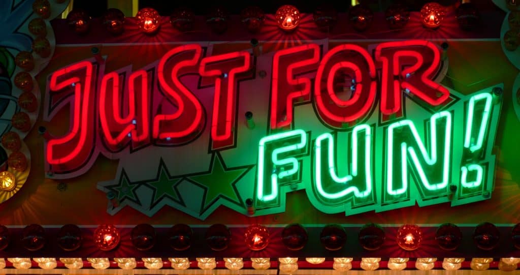 NEON SIGN IN RED AND GREEN THAT SAYS JUST FOR FUN.