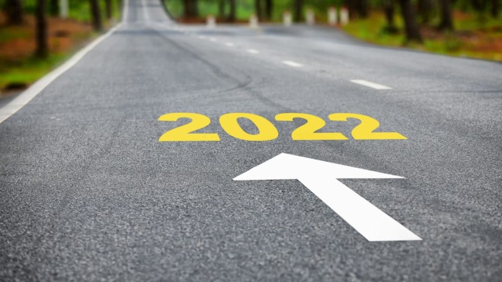 A PAVED ROAD WITH THE NUMBERS 2022 IN YELLOW AND ARROW FORWARD